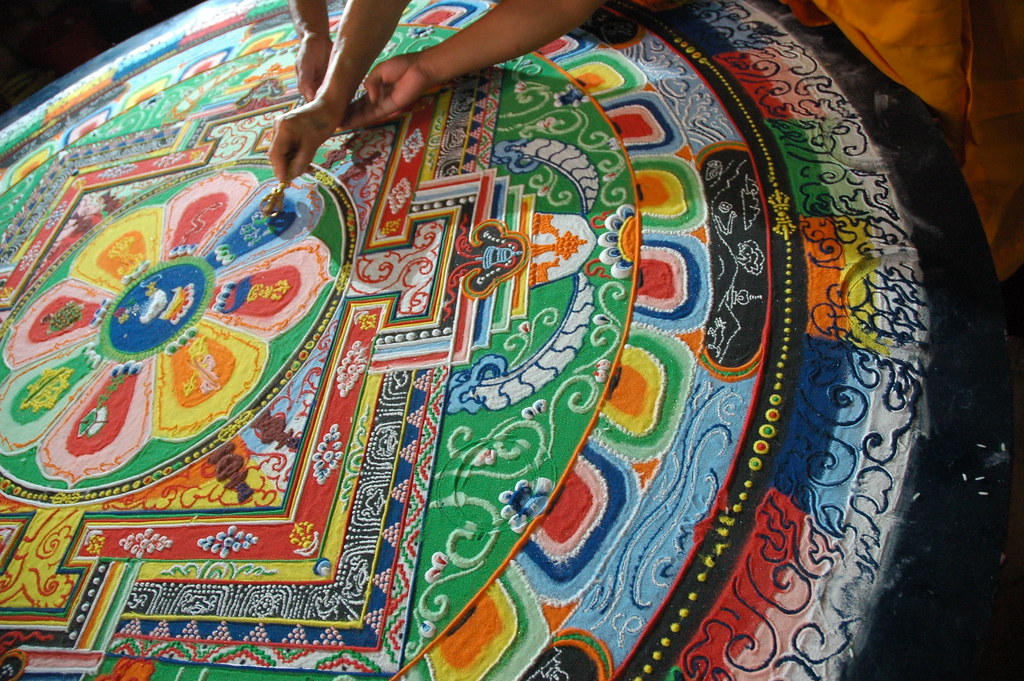 His Holiness Dagchen Rinpoche's hand holds a vajra drawing lines that close the Hevajra Mandala, after the emp